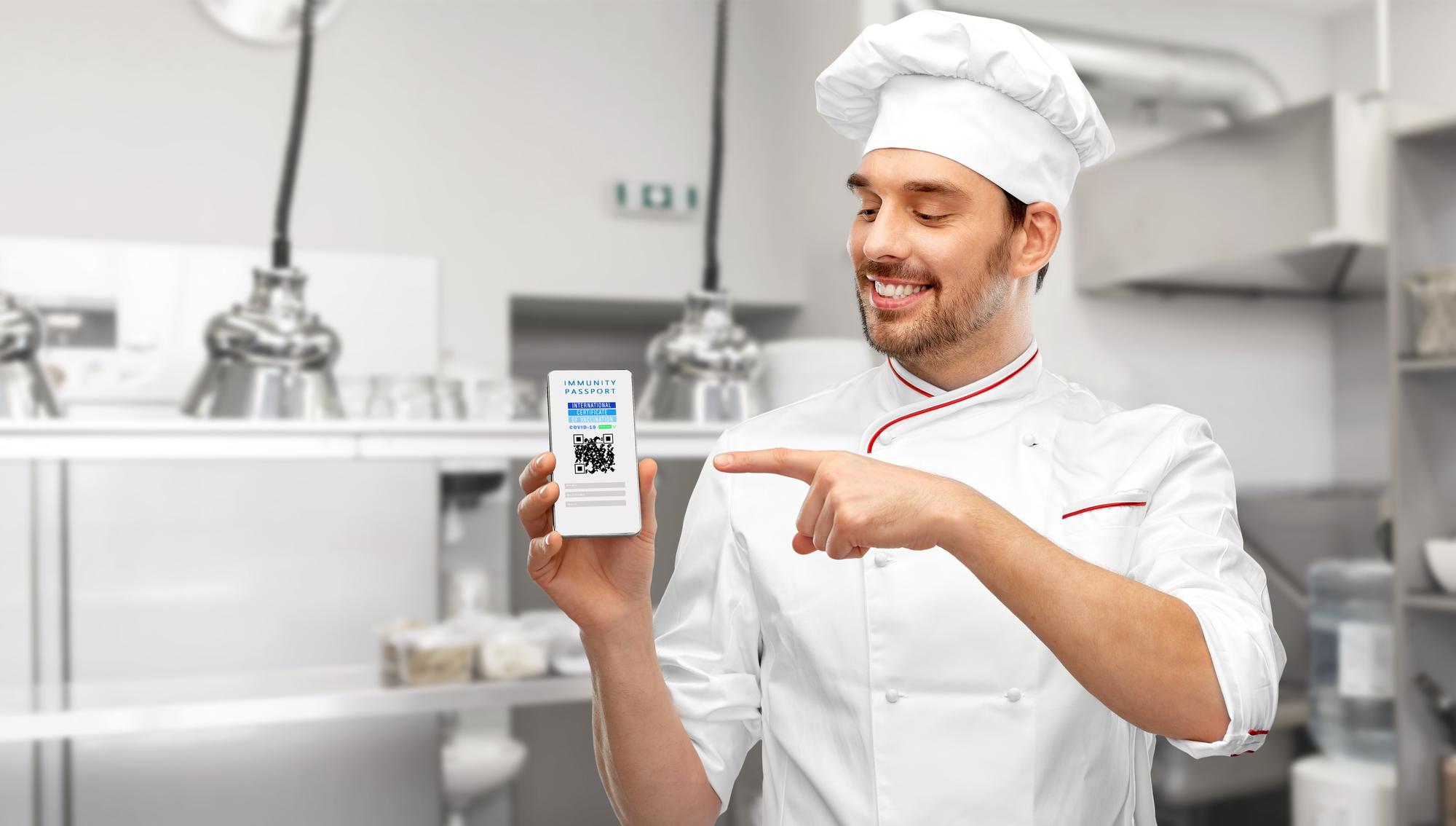 Chef zeigt Rezeptkarte mit QR